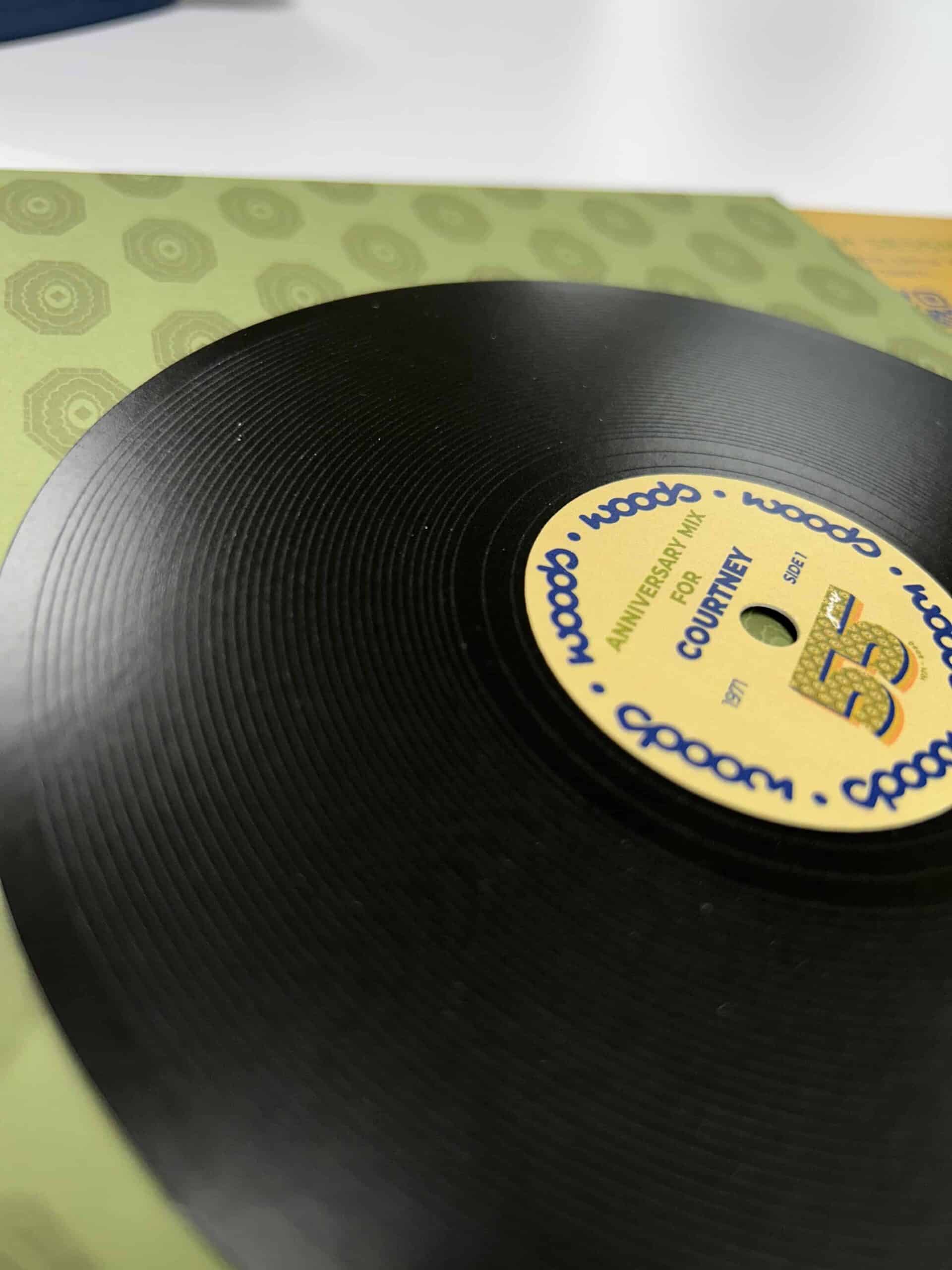 Close-up of a custom printed vinyl record label for a Branded by Woods anniversary mix, showing coordinated color, pattern, and finish